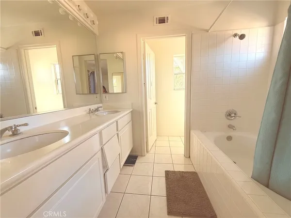 a spacious bathroom with a tub sink and mirror