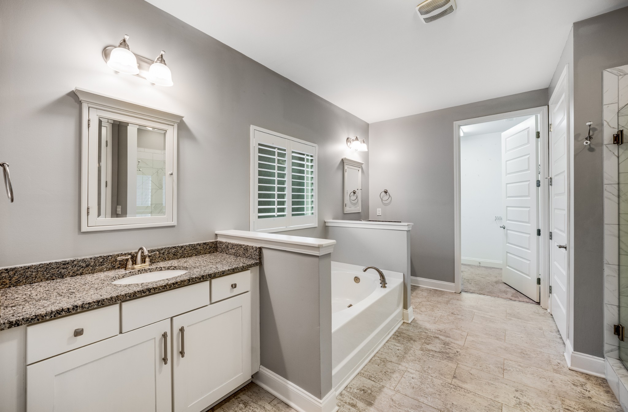 5001 Rizer Point Drive Franklin, TN 37069 - Photo 12 of 42 a spacious bathroom with a granite countertop sink a mirror a vanity and a bathtub