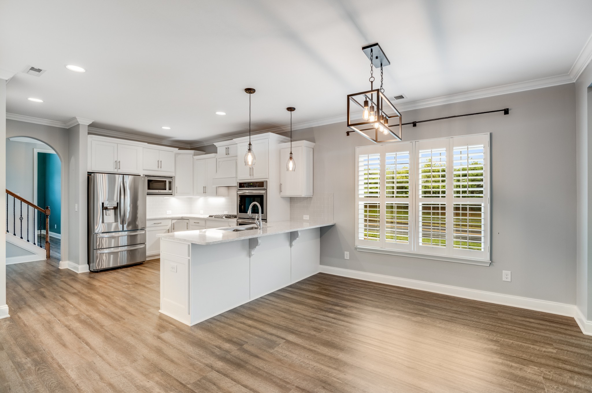 5001 Rizer Point Drive Franklin, TN 37069 - Photo 20 of 42 a kitchen with stainless steel appliances granite countertop a refrigerator a sink dishwasher a stove and white cabinets with wooden floor