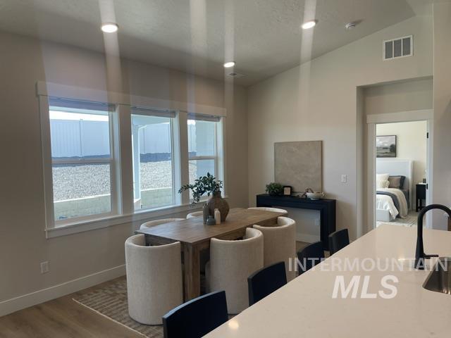 2035 Sumac Avenue Middleton, ID 83644 - Photo 5 of 17 Open-concept dining area featuring wood-finish flooring, a trio of large windows, and recessed lighting