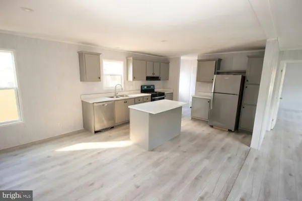 a kitchen with a sink a refrigerator and cabinets