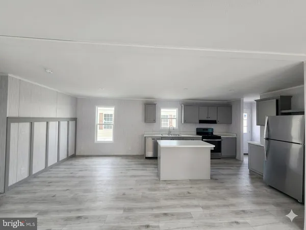 a kitchen with a refrigerator and a stove top oven