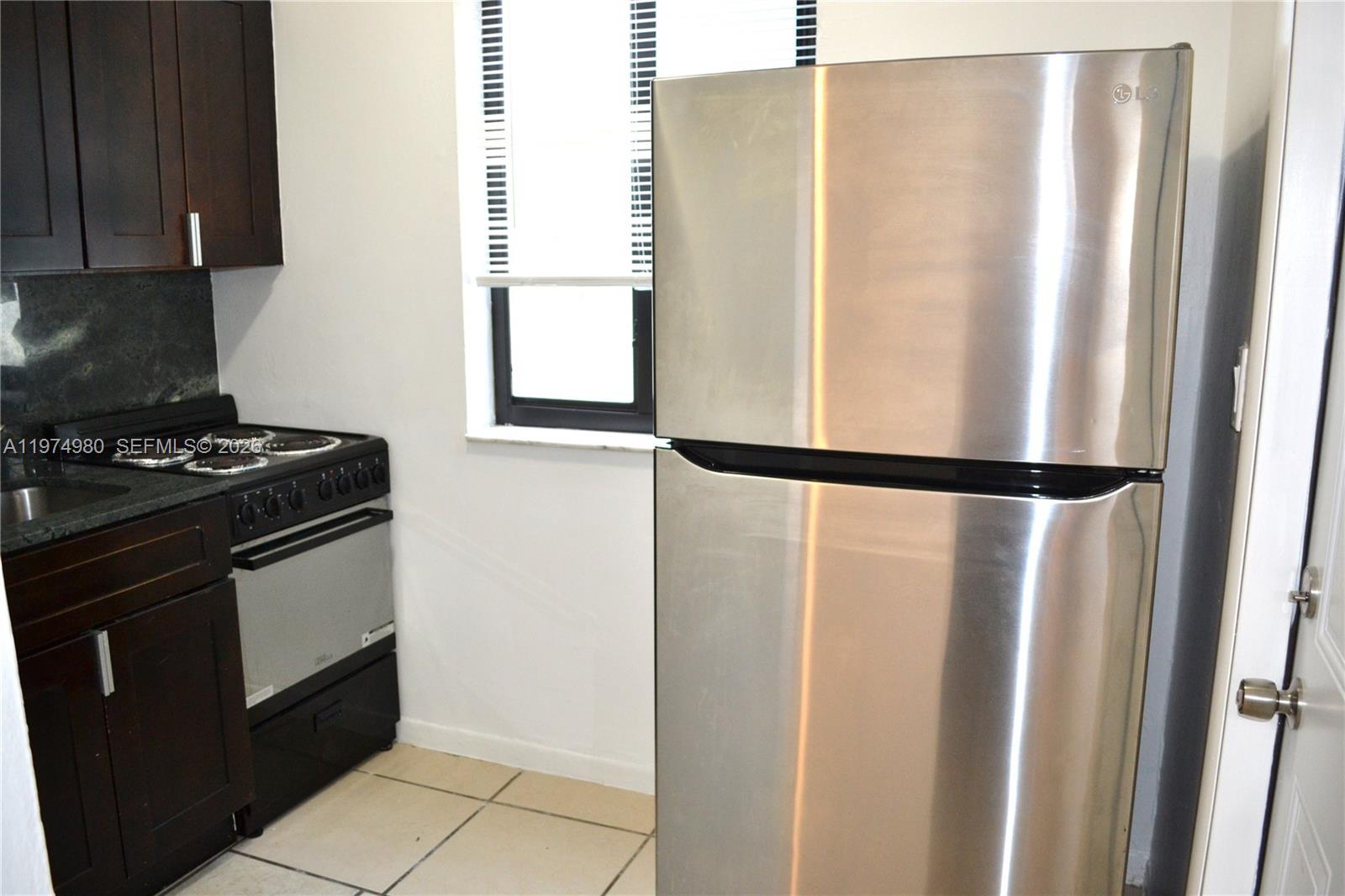 1035 Southwest 4th Street, Unit 2 Miami, FL 33130 - Photo 7 of 11 a kitchen with stainless steel appliances granite countertop a refrigerator and a stove