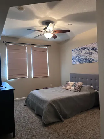 a bedroom with a bed lamp and a chandelier