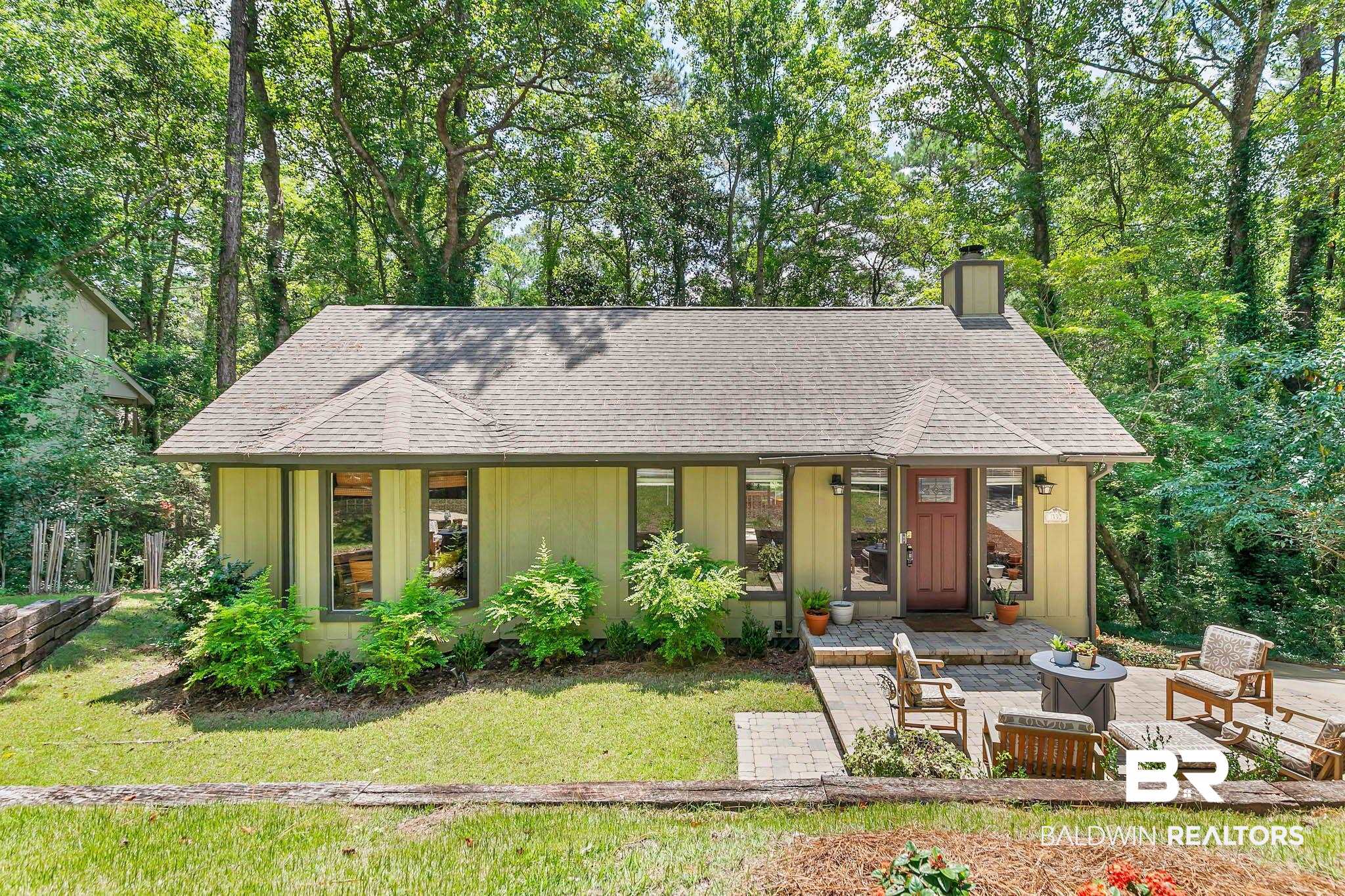 332 Ridgewood Drive Daphne, AL 36526 - Photo 1 of 48 View of front of house featuring a chimney, roof with shingles, view of wooded area, a front yard, and board and batten siding