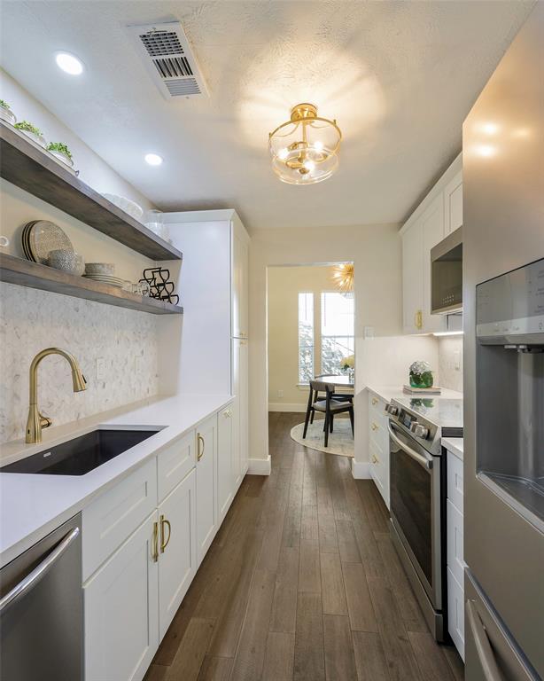 3605 Brown Street, Unit 106 Dallas, TX 75219 - Photo 1 of 19 a kitchen with kitchen island granite countertop stainless steel appliances a sink stove top oven and cabinets