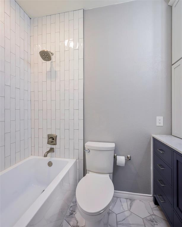 3605 Brown Street, Unit 106 Dallas, TX 75219 - Photo 12 of 19 a white toilet sitting next to a bathtub