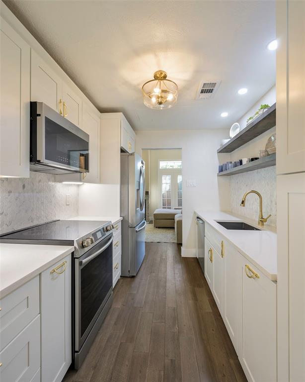 3605 Brown Street, Unit 106 Dallas, TX 75219 - Photo 9 of 19 a kitchen with a stove a sink and wooden floor