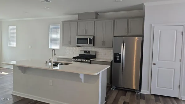 a kitchen with stainless steel appliances a refrigerator sink and microwave
