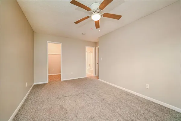 an empty room with a ceiling fan and a window