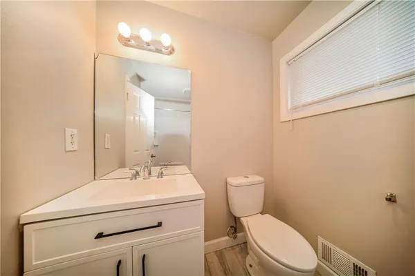 a bathroom with a sink mirror vanity and toilet