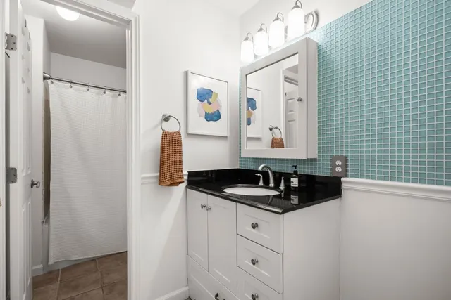 a bathroom with a granite countertop sink and a mirror