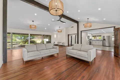 a living room with furniture kitchen and a large window