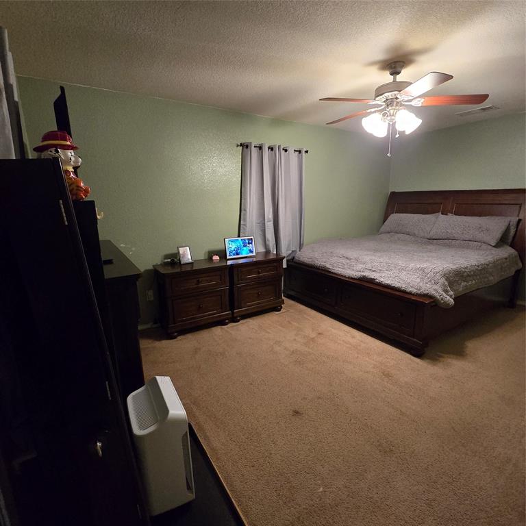 212 Druse Lane Jarrell, TX 76537 - Photo 4 of 38 a bedroom with a bed and a chandelier