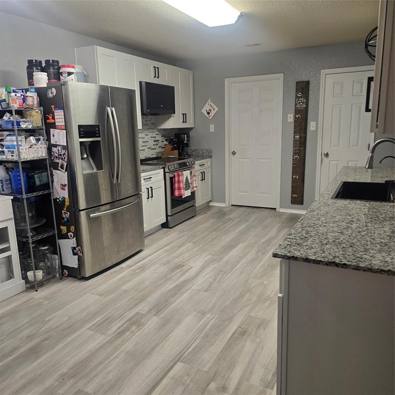 212 Druse Lane Jarrell, TX 76537 - Photo 7 of 38 a kitchen with granite countertop a refrigerator and a sink