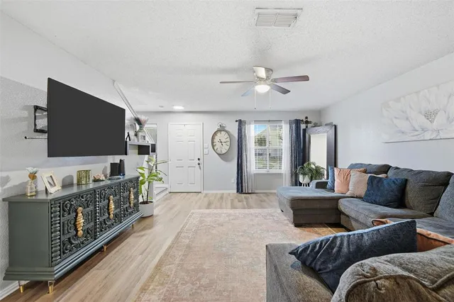 a living room with furniture a flat screen tv and a potted plant