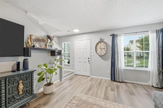 a living room with furniture a flat screen tv and a large window