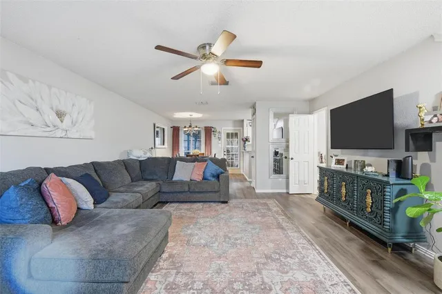 a view of an empty room with kitchen and a window