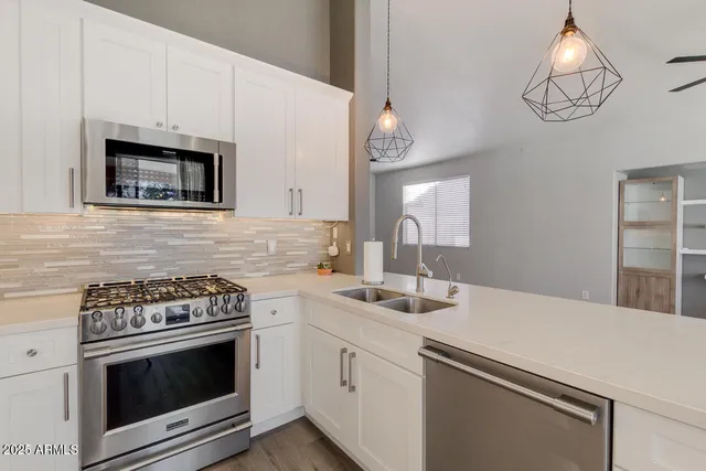 a kitchen with cabinets stainless steel appliances and a sink