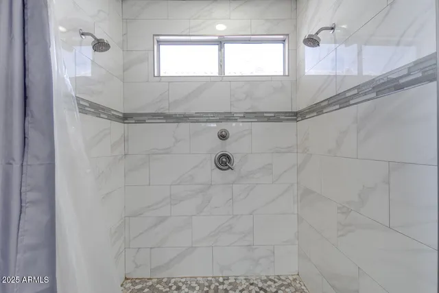 a bathroom with a granite countertop shower and mirror