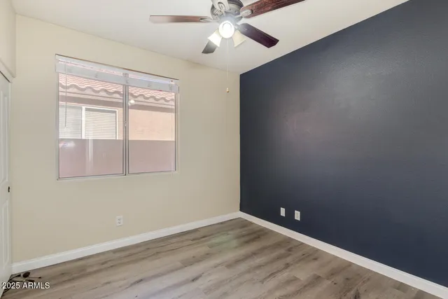 an empty room with a window and a fan