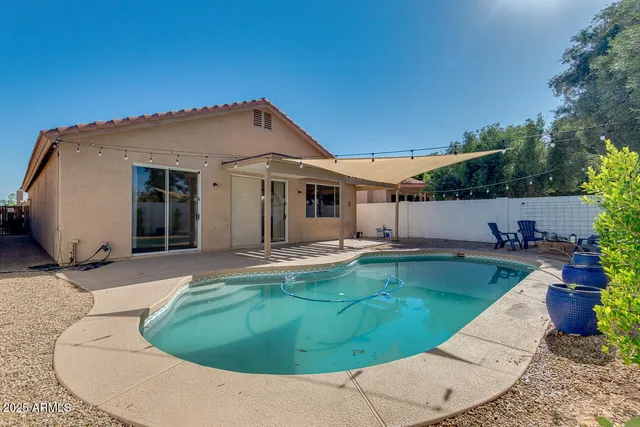 a view of a house with swimming pool and sitting area