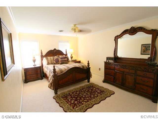 4020 Poplar Grove Road Midlothian, VA 23112 - Photo 6 of 12 a bedroom with a bed and dresser with mirror