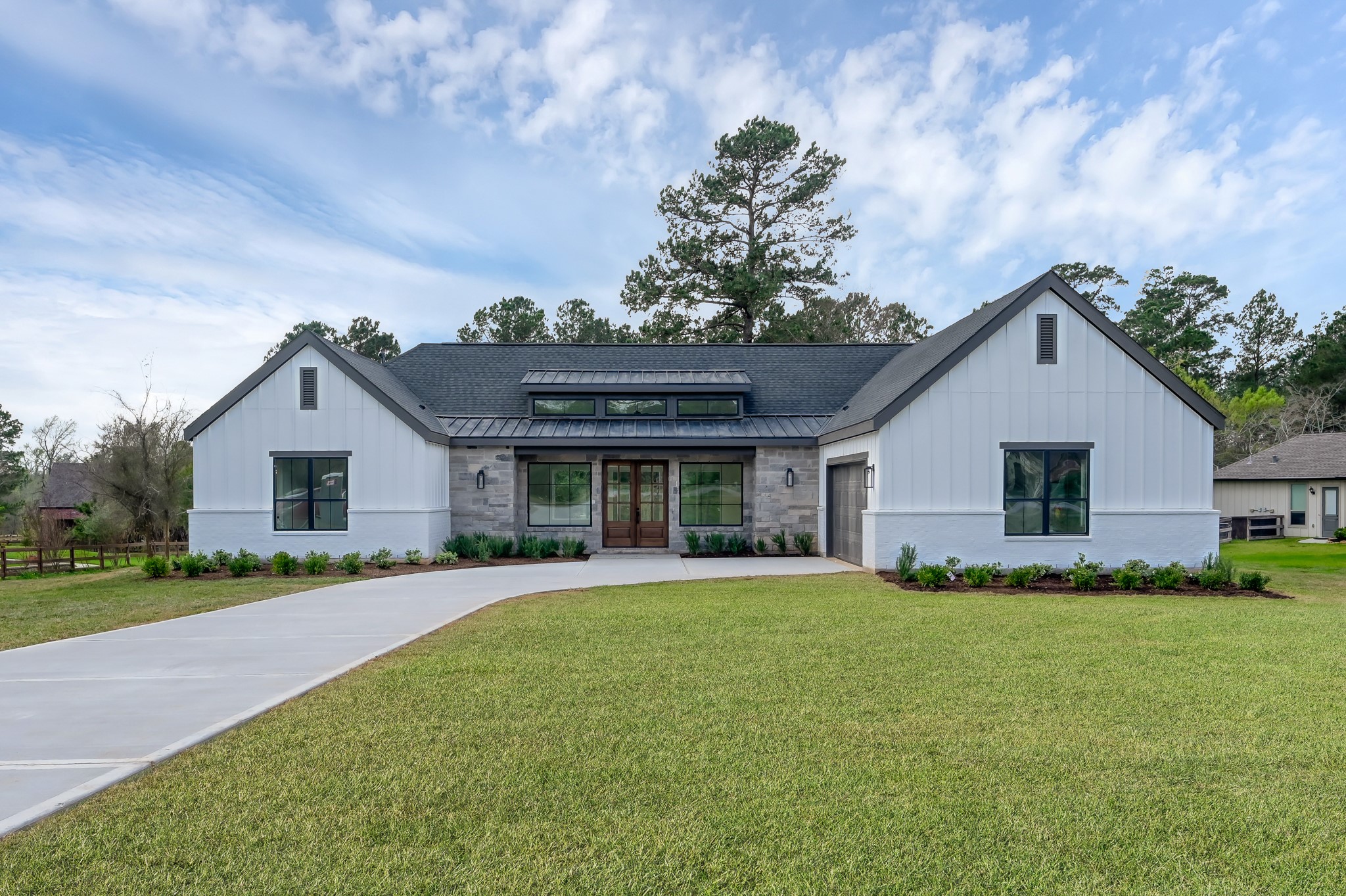 14742 Turquoise Trail Willis, TX 77378 - Photo 1 of 48 Front elevation showcasing the home’s balanced design, large windows, and inviting entry. The manicured lawn and professional landscaping enhance the property’s curb appeal.