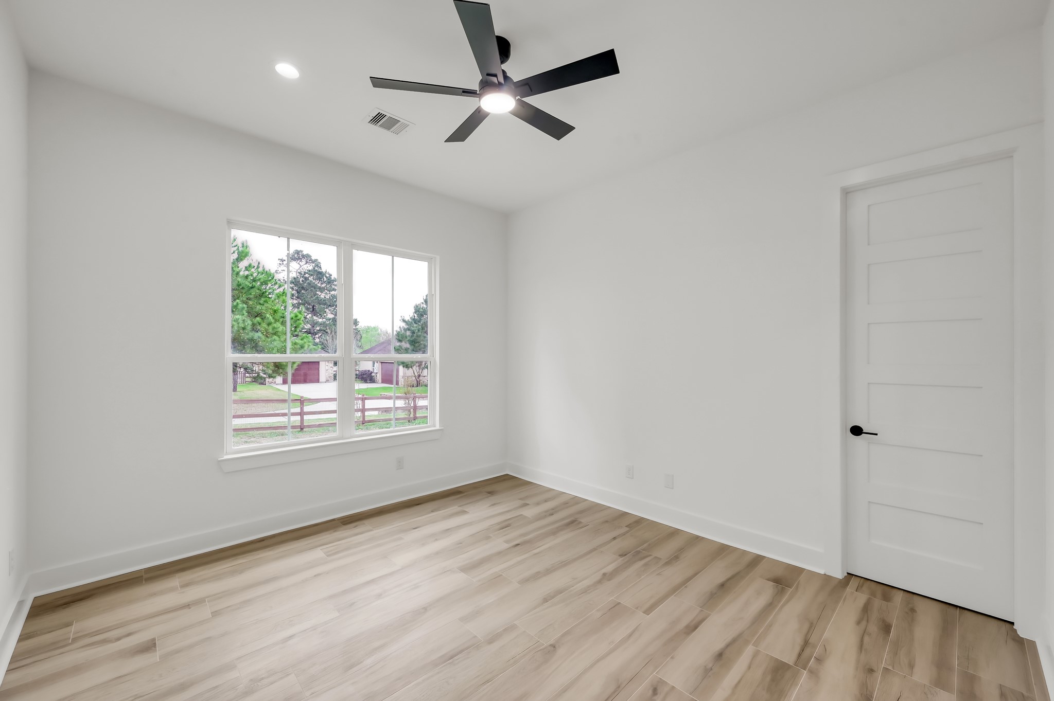 14742 Turquoise Trail Willis, TX 77378 - Photo 22 of 48 an empty room with wooden floor ceiling fan and windows
