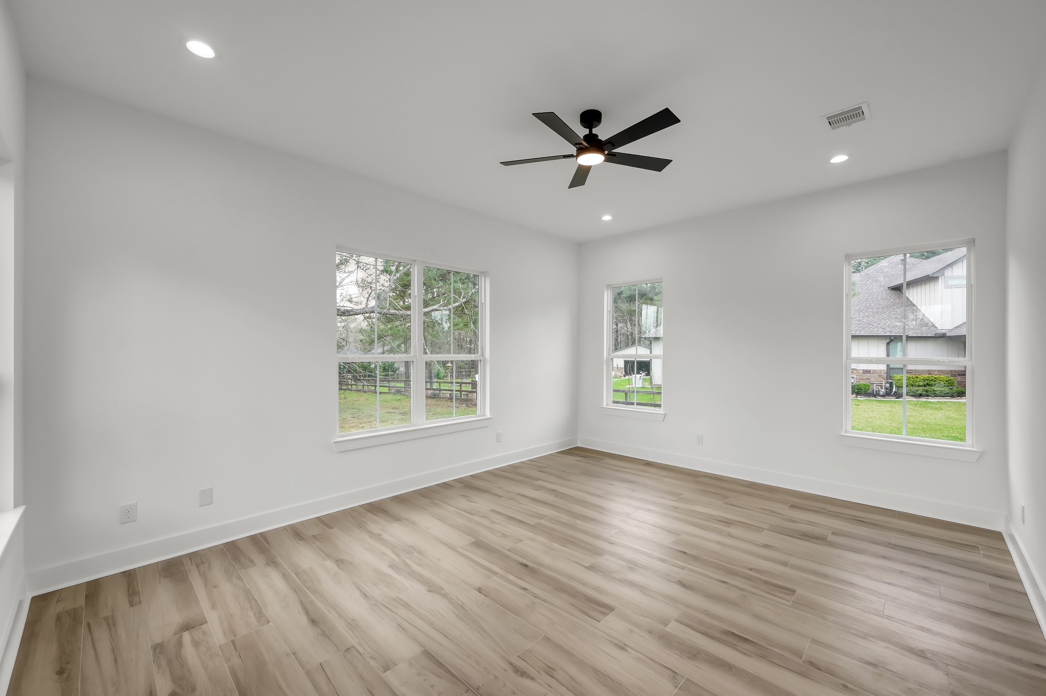 14742 Turquoise Trail Willis, TX 77378 - Photo 24 of 48 Expansive primary suite with large windows that fill the room with natural light and provide peaceful views of the property. Neutral tones and high ceilings create a relaxing retreat.