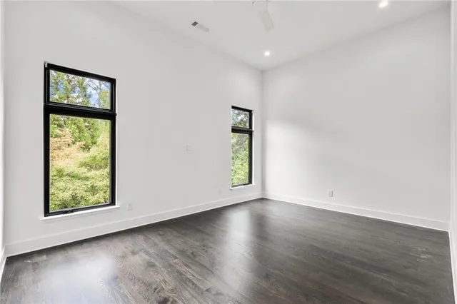 an empty room with wooden floor and windows