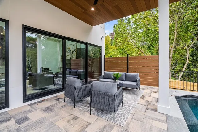 a living room with patio furniture and garden view