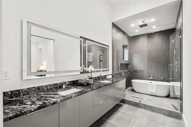 a bathroom with a double vanity sink a mirror and a bathtub