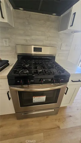 a view of a kitchen with wooden floor and electronic appliances