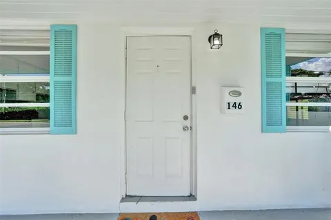 a kitchen with stainless steel appliances granite countertop white cabinets a window and a sink