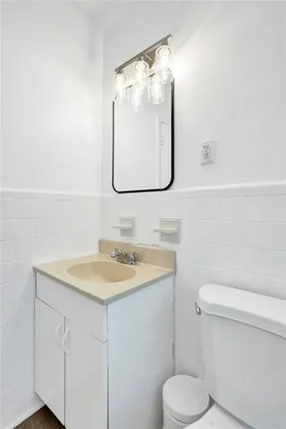 a view of a white house with a big yard potted plants and large tree