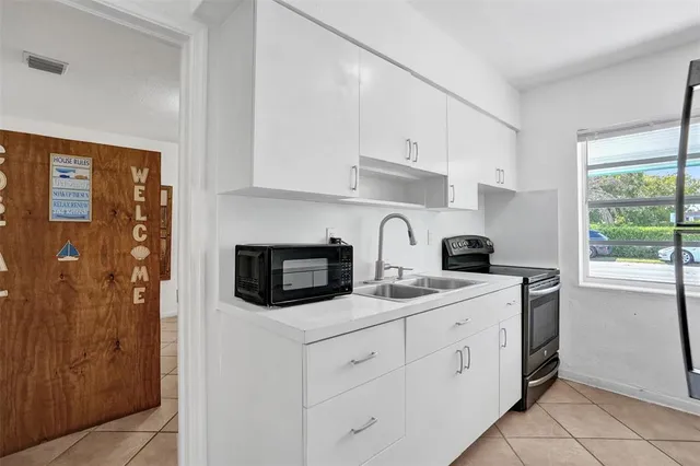 a kitchen with stainless steel appliances granite countertop white cabinets a granite counter tops and a window