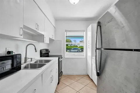a kitchen with a refrigerator sink and cabinets