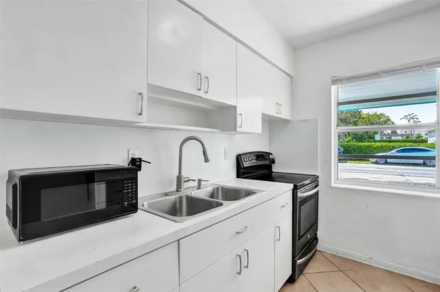 a kitchen with stainless steel appliances white cabinets and a stove top oven