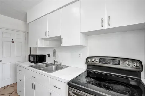 a kitchen with a refrigerator sink and cabinets