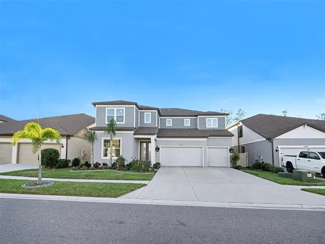 a front view of house with yard and trees in the background