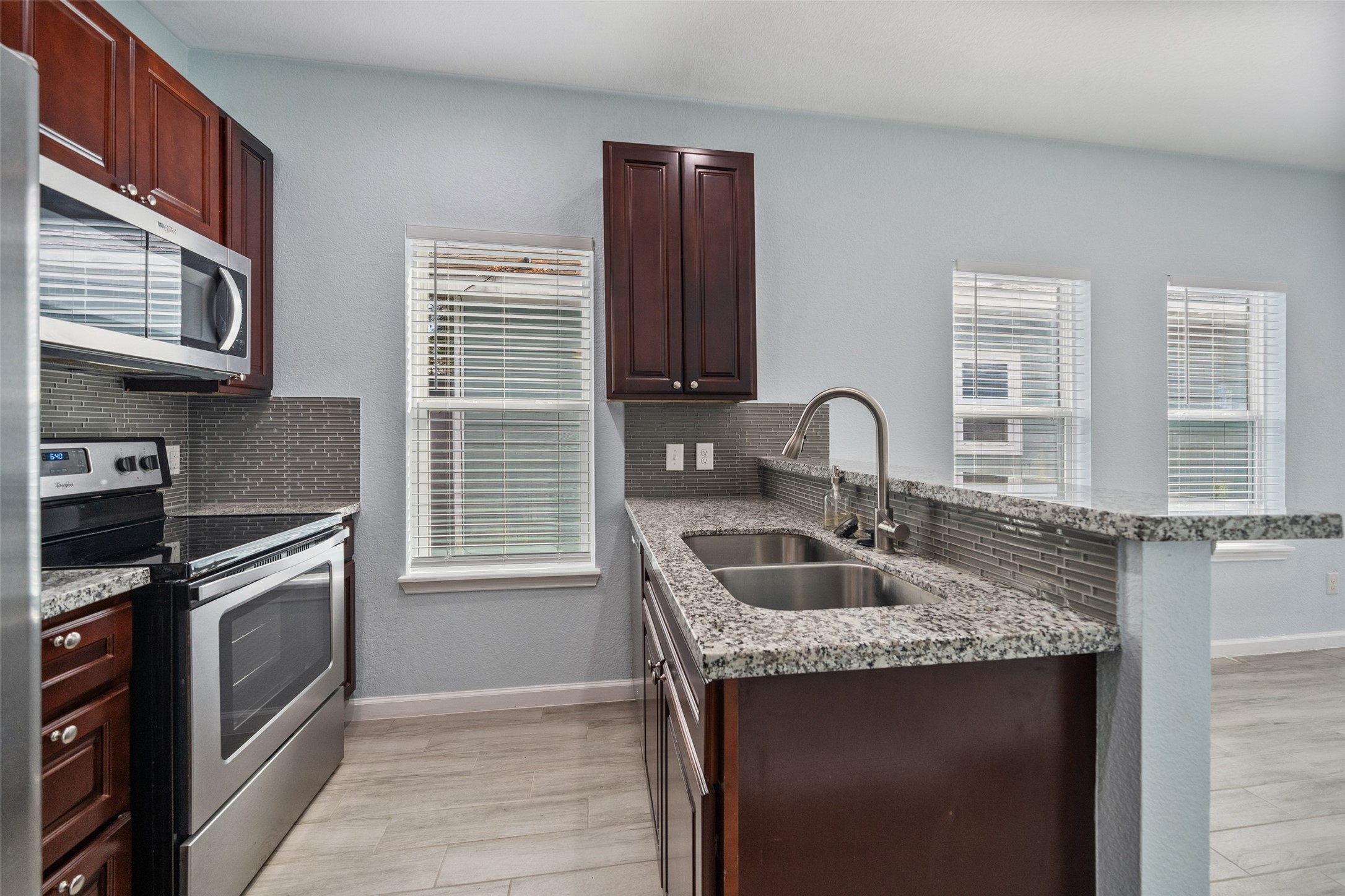 241 Ridgeside Court Montgomery, TX 77316 - Photo 11 of 30 a kitchen with granite countertop a sink and a stove
