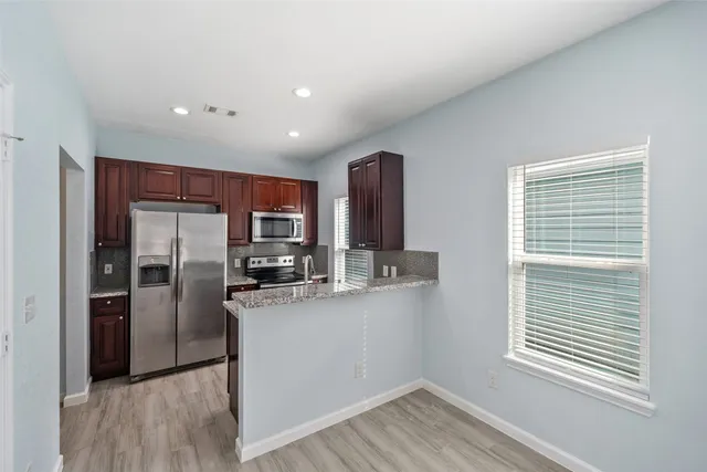 a kitchen with stainless steel appliances granite countertop a refrigerator and a sink