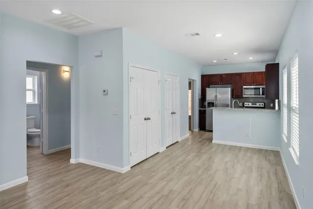 a view of a kitchen with a refrigerator a microwave and a sink