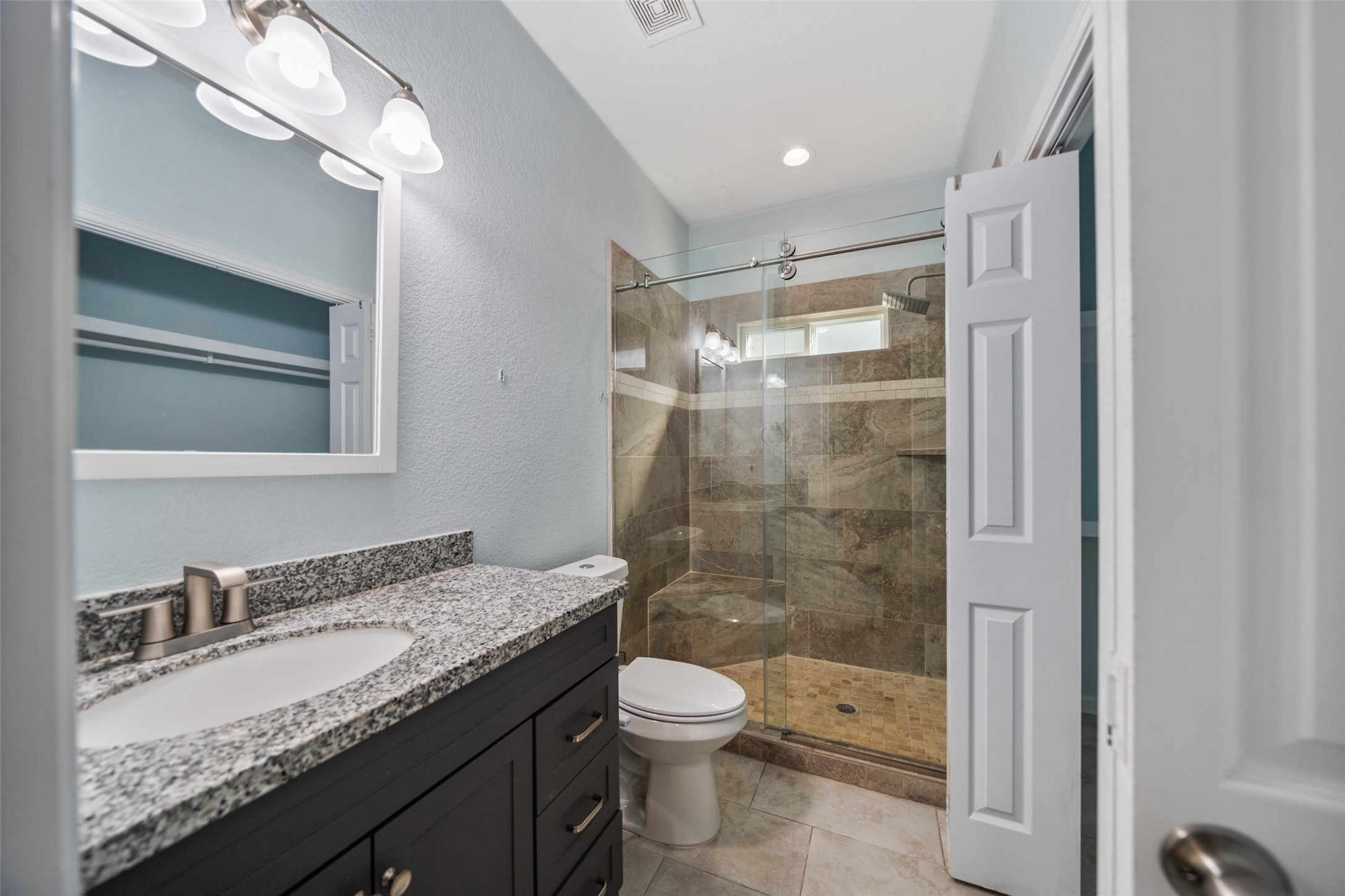 241 Ridgeside Court Montgomery, TX 77316 - Photo 18 of 30 a bathroom with a granite countertop sink toilet a mirror and shower