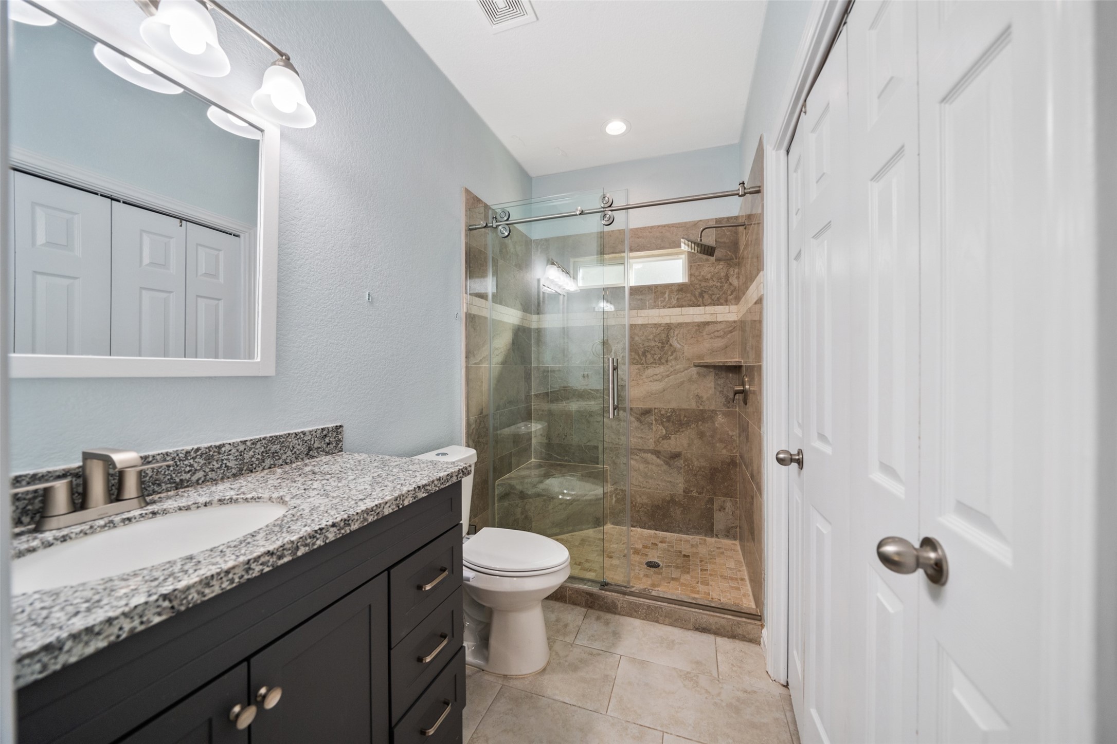 241 Ridgeside Court Montgomery, TX 77316 - Photo 19 of 30 a bathroom with a granite countertop sink a toilet a mirror and shower
