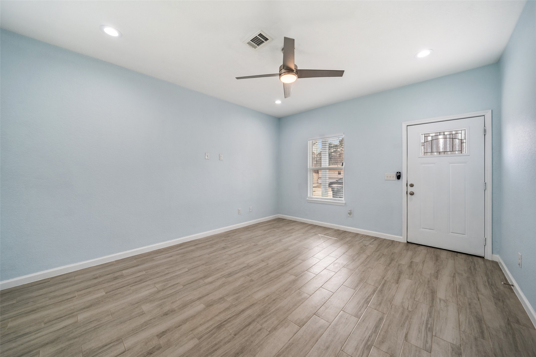 241 Ridgeside Court Montgomery, TX 77316 - Photo 6 of 30 an empty room with wooden floor ceiling fan and windows