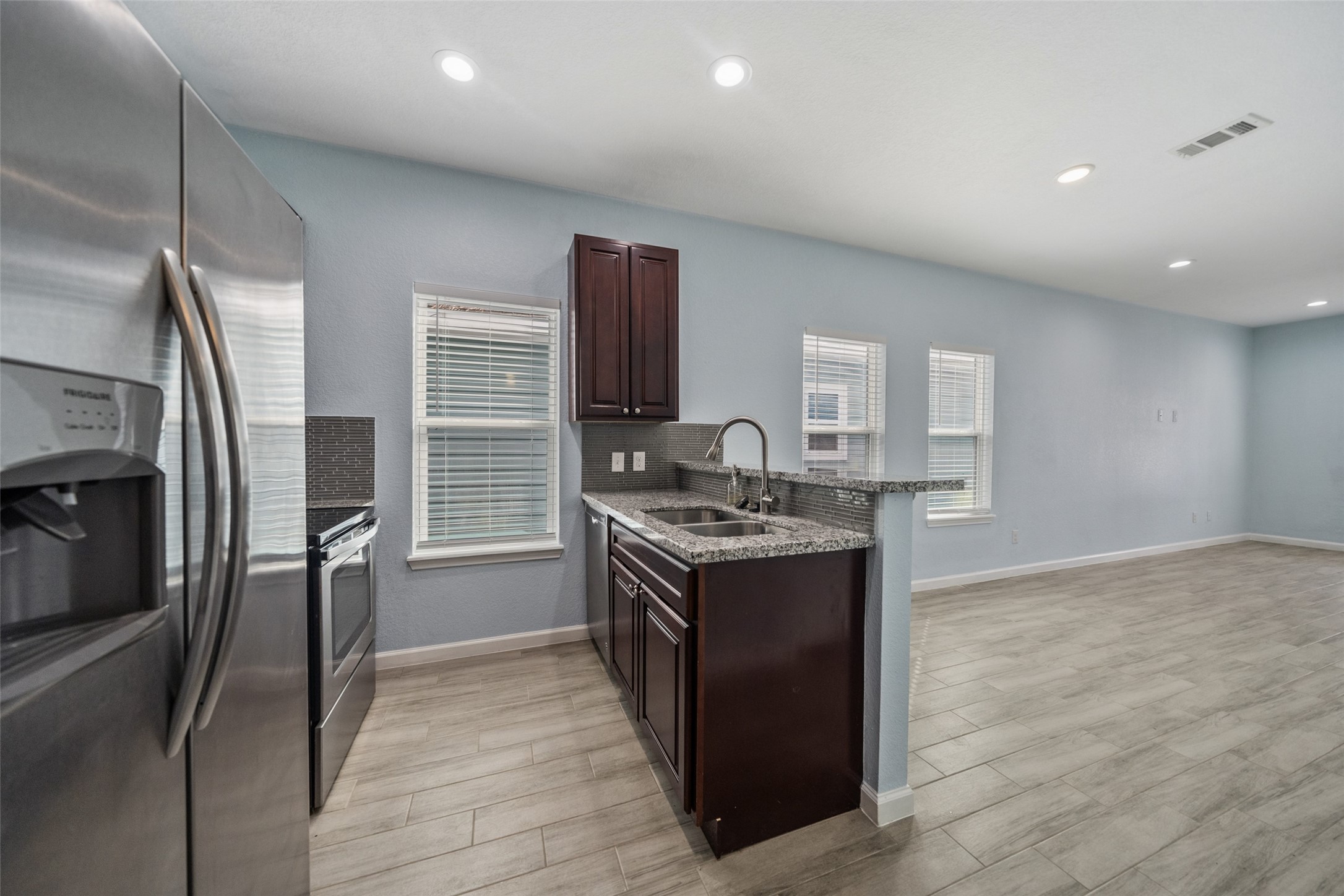 241 Ridgeside Court Montgomery, TX 77316 - Photo 10 of 30 a kitchen with stainless steel appliances granite countertop a stove and a refrigerator