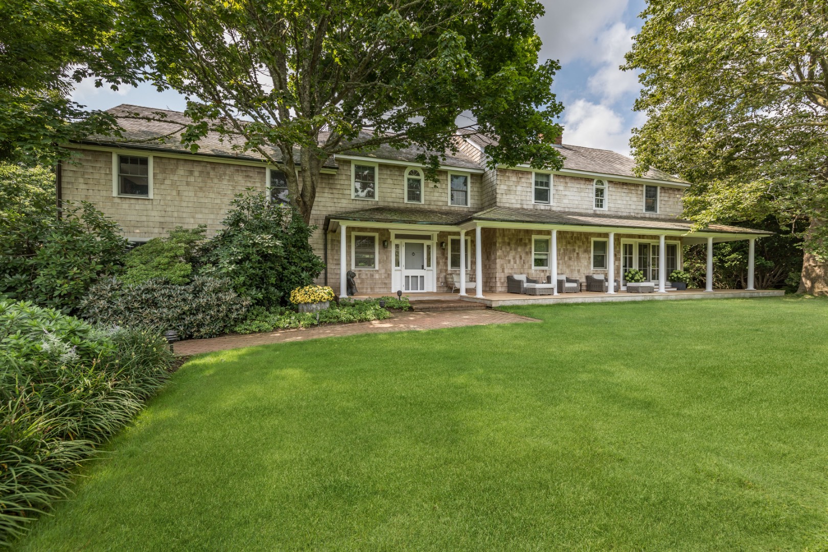 227 Sagaponack Road Bridgehampton, NY 11932 - Photo 2 of 26 a front view of a house with a yard table and chairs