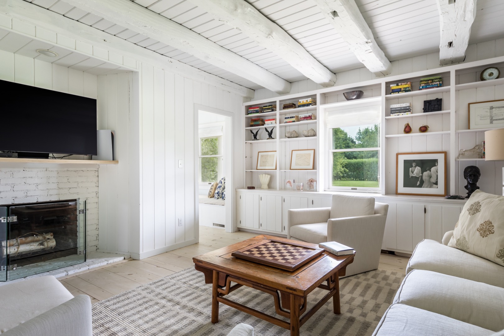 227 Sagaponack Road Bridgehampton, NY 11932 - Photo 17 of 26 a living room with furniture a flat screen tv and a fireplace